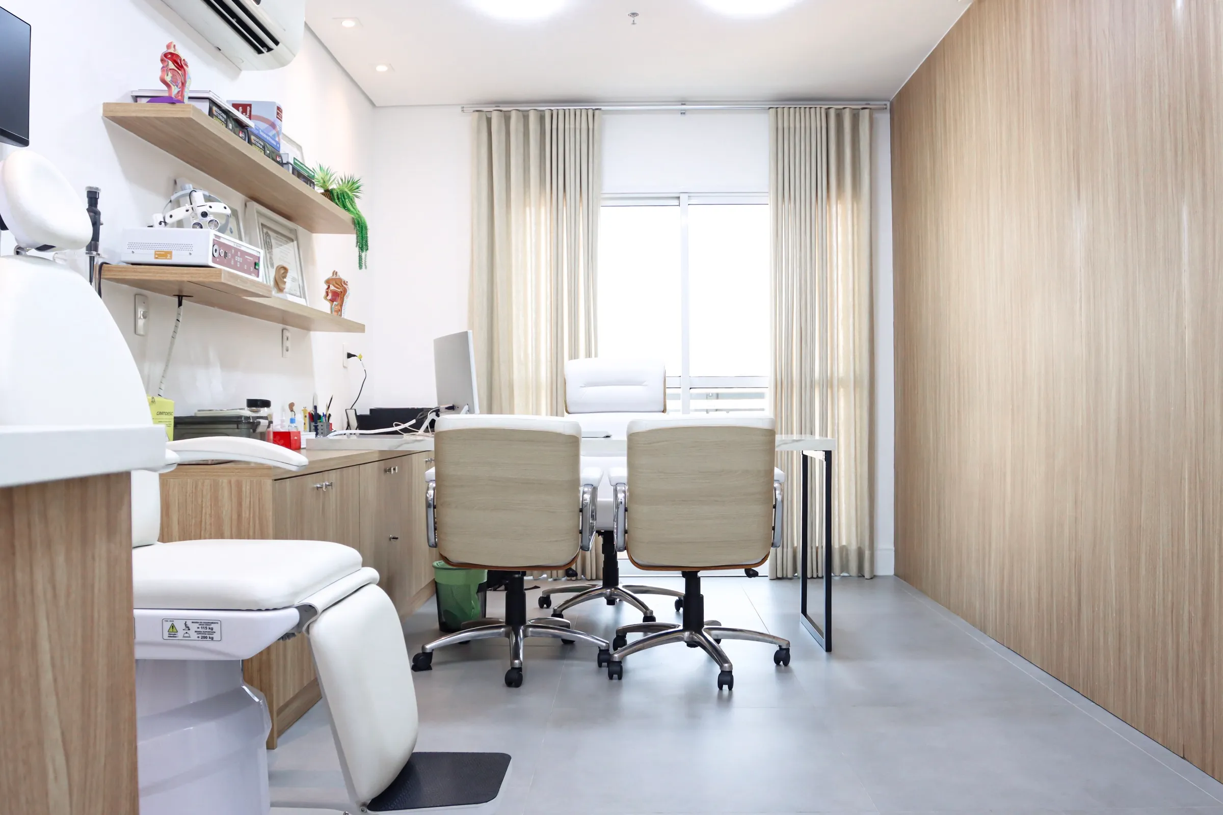 Consultório com mesa e cadeira de exame